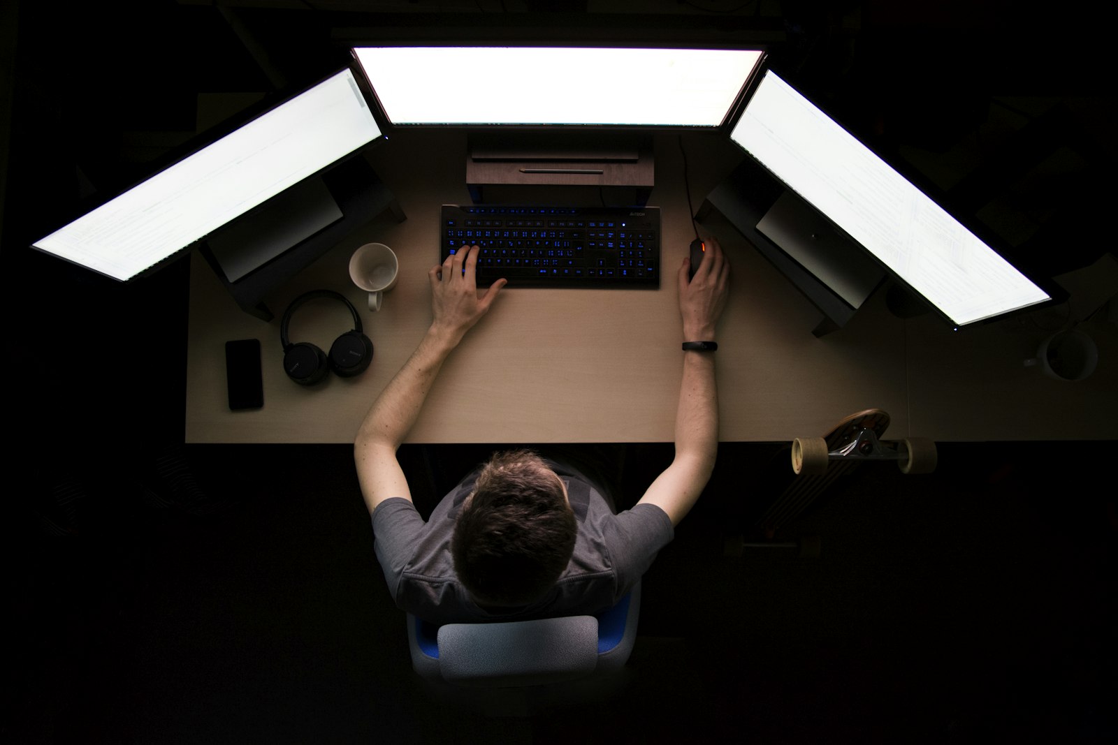 Χειριστής παρακολουθεί τρεις οθόνες εργασίας από ψηλά