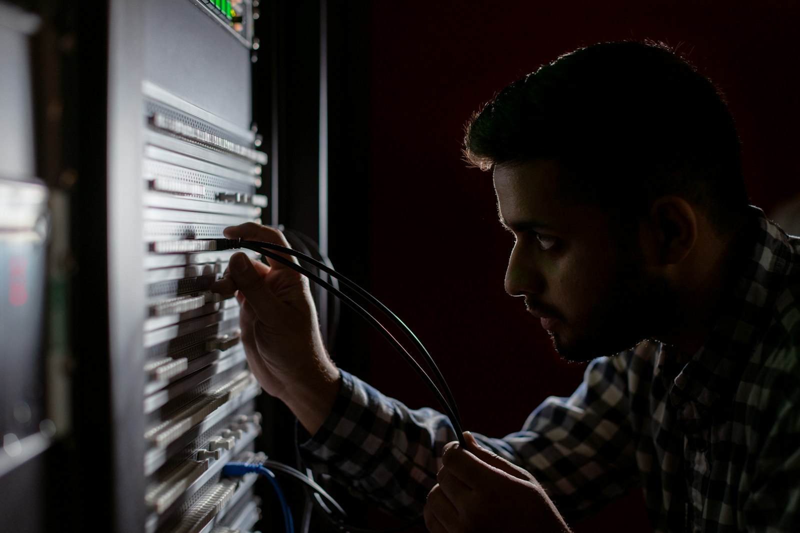 Τεχνικός συνδέει καλώδια δικτύου σε rack εξοπλισμού